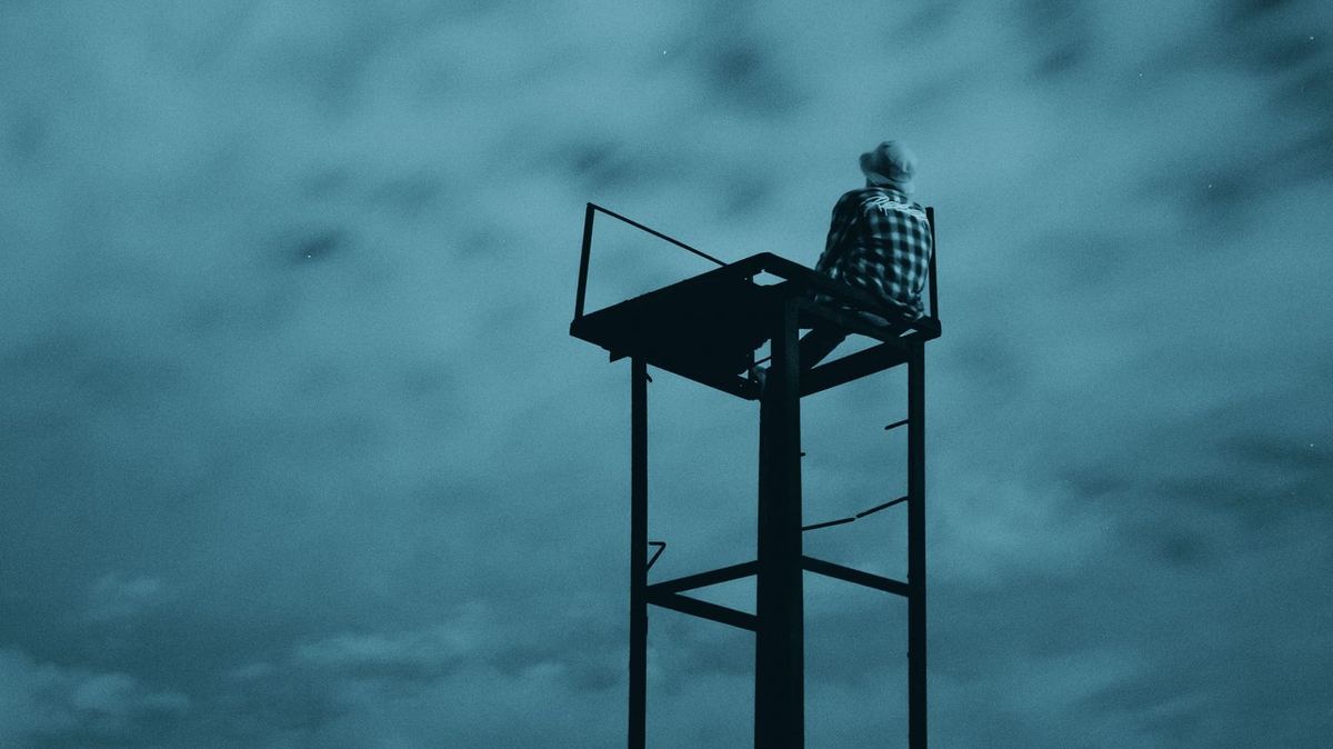 Persoon die vanaf een hoog uitkijkpunt over het landschap kijkt